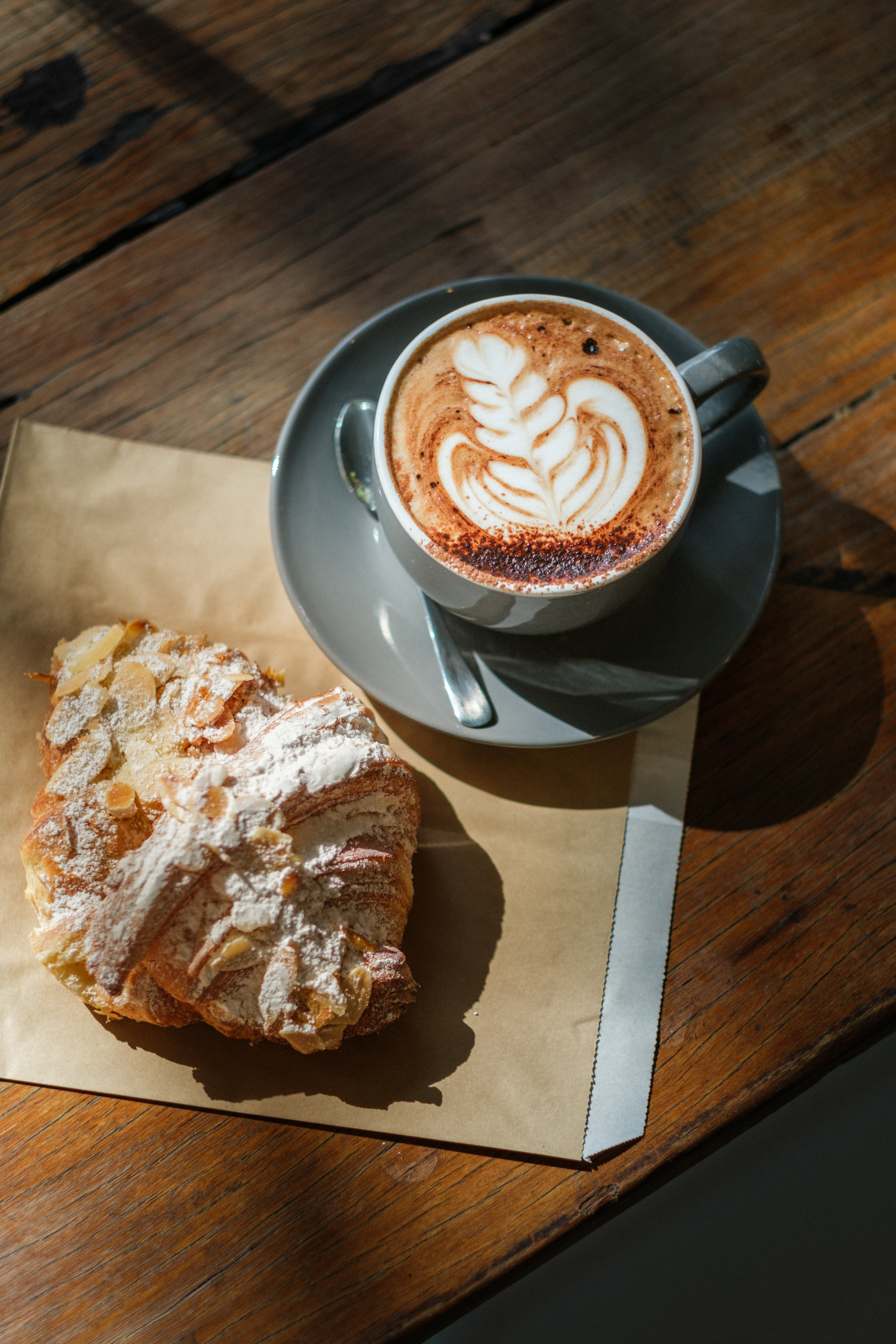 Latte with art and an almond croissant